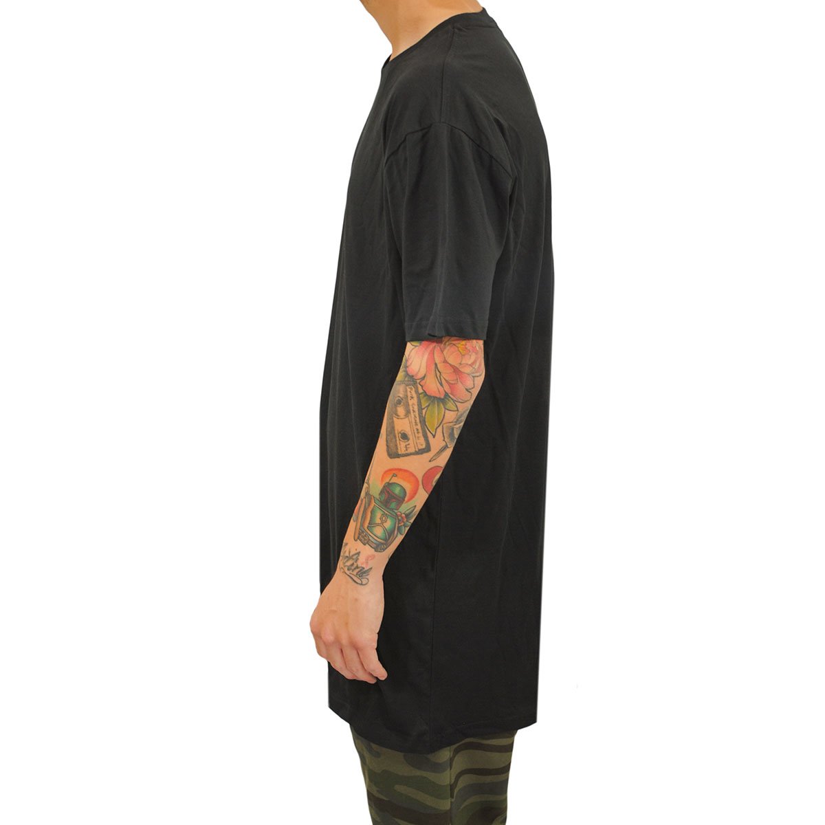 Tall male model 6,4 wearing a large black Have It Tall Extra Long 100% Cotton Luxury Medium weight mens t-shirt side profile against a white background.