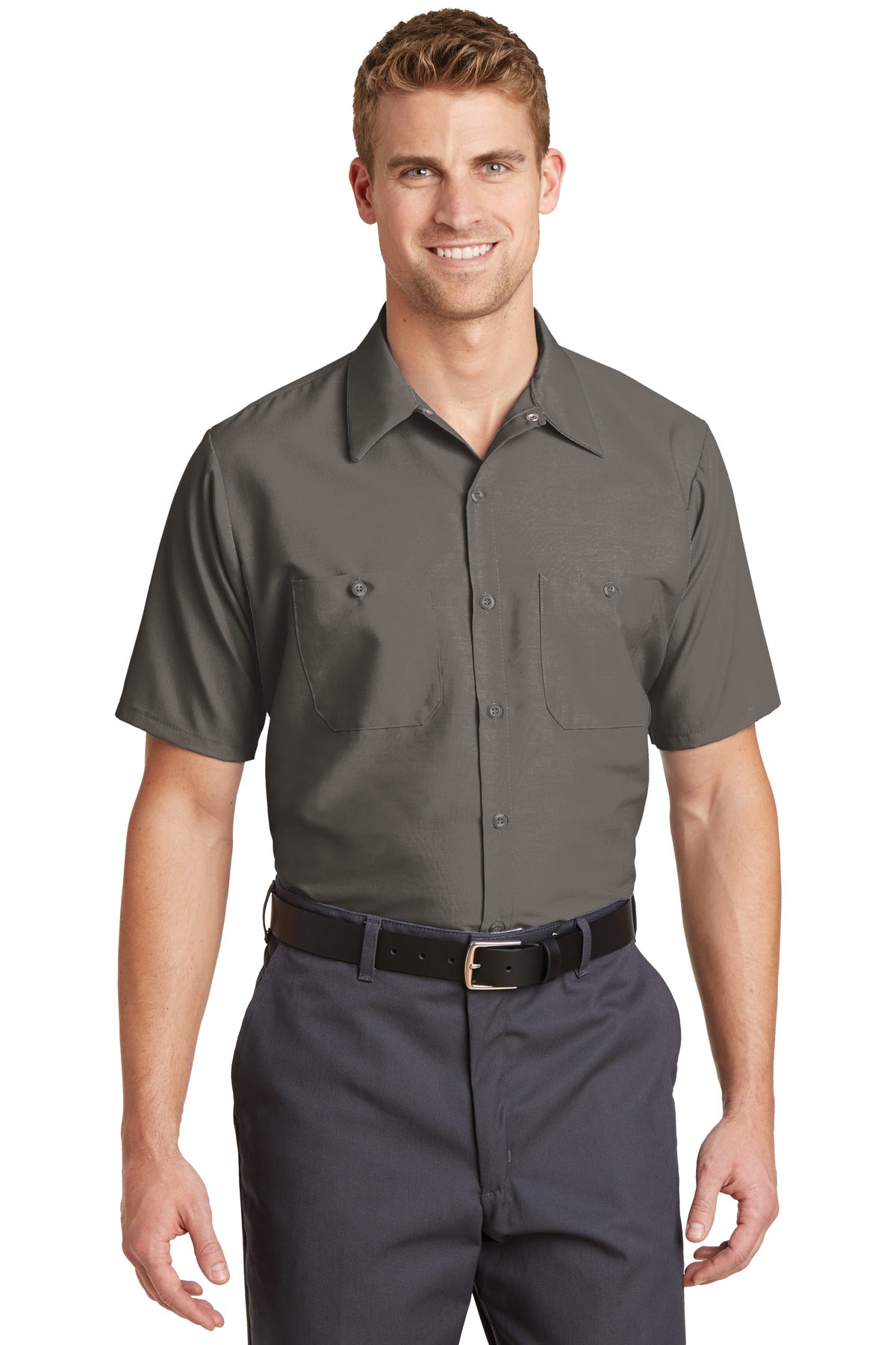 Tall male model 6'3 wearing a medium Red Kap Long Size Short Sleeve button up tee shirt Industrial Work Shirt in grey with dyed buttons against a white background
