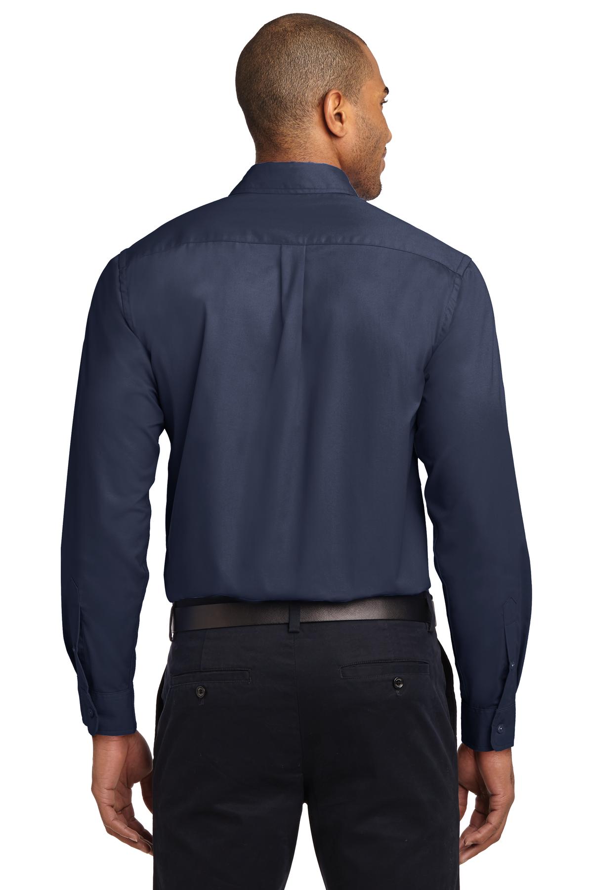 Tall male model 6,3 wearing a Medium long sleeve port authority button up shirt with chest pocket in color navy showing the back of the shirt against a white background