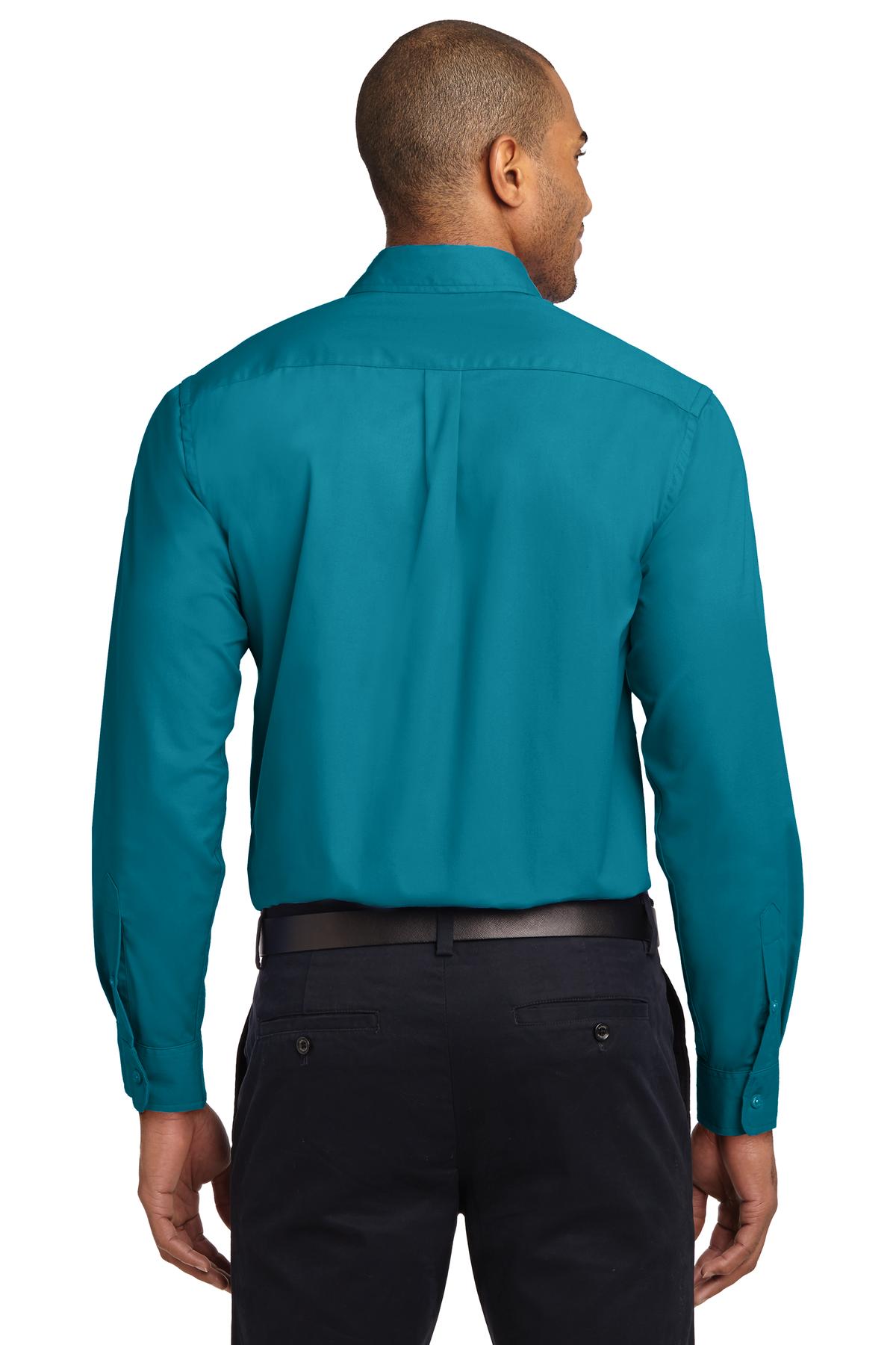 Tall male model 6,3 wearing a Medium long sleeve port authority button up shirt with chest pocket in color teal showing the back of the shirt against a white background