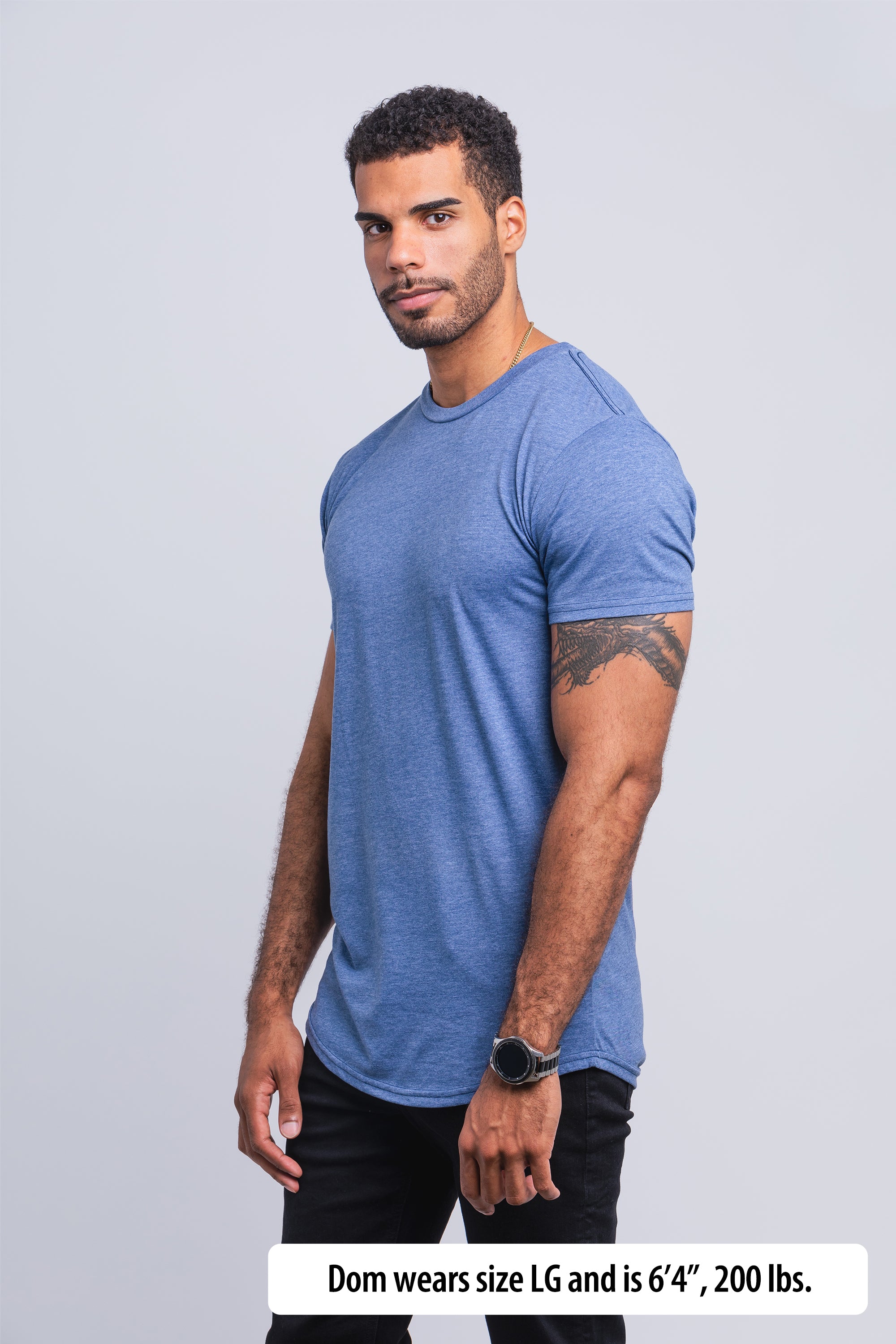 Have It Tall Curve Bottom Tall T Shirt worn by a male model (6'4" tall) wearing a size large Athletic Blue standing in a tall apparel showroom.