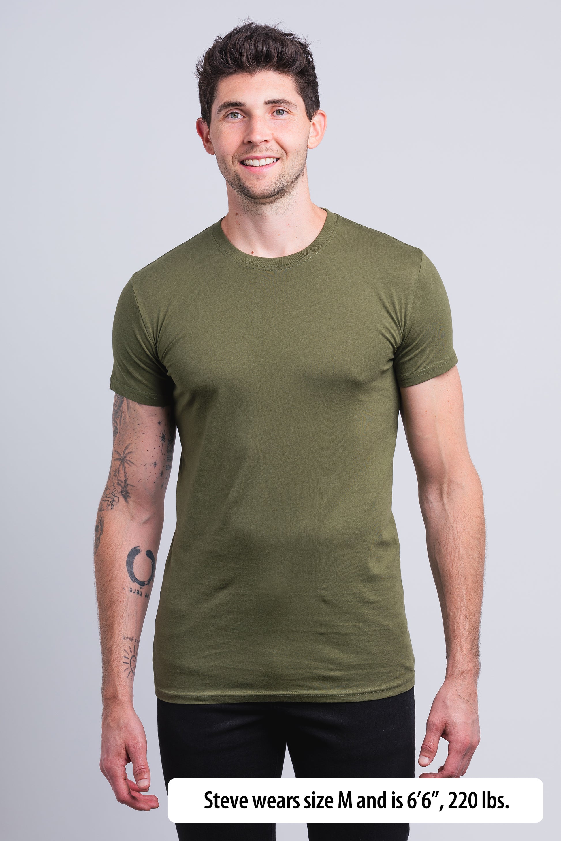 Have It Tall Classic Tall T Shirt worn by a male model (6'6" tall) wearing a size Medium Olive Drab standing in a tall apparel showroom.