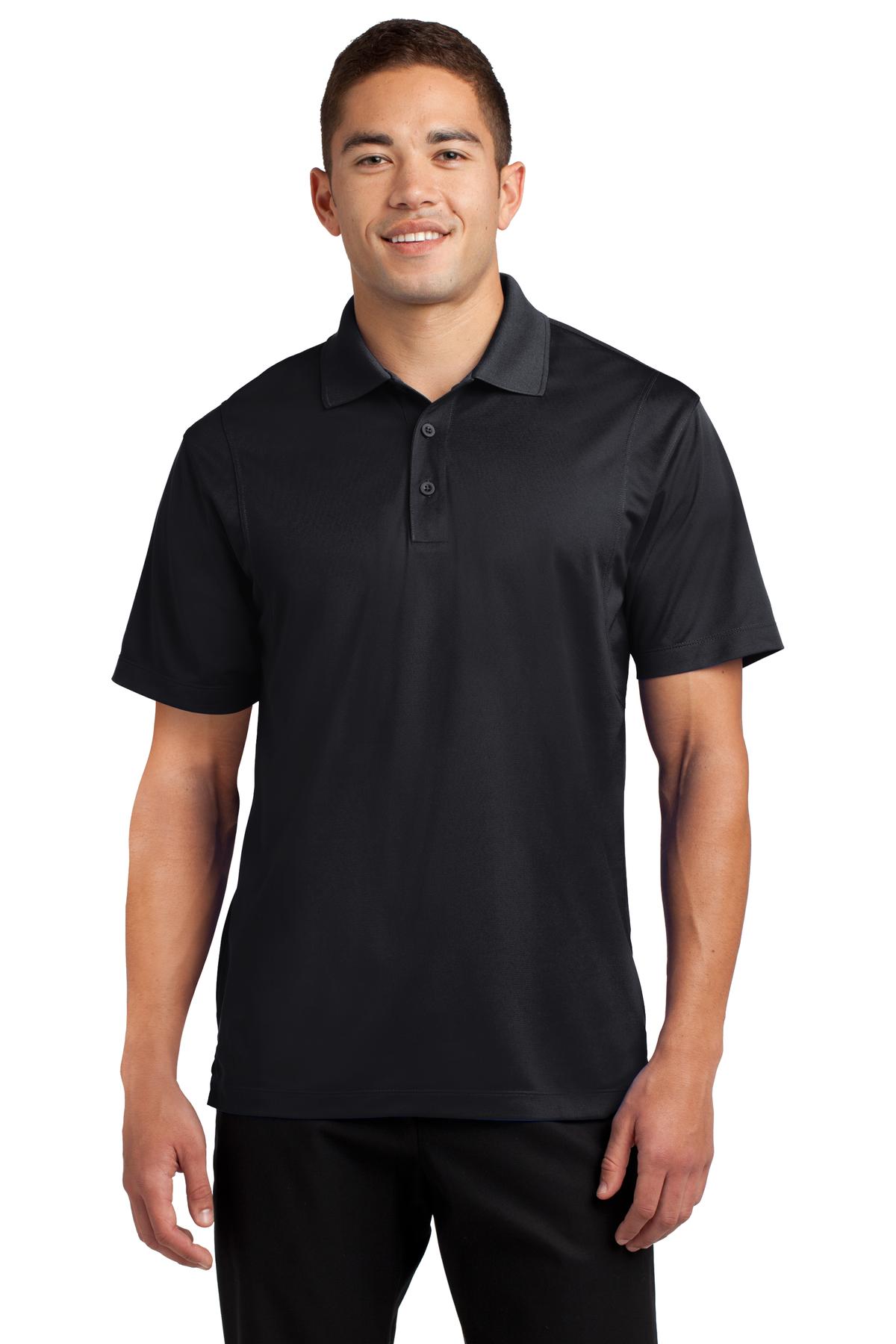 Tall male model 6'4 wearing a medium sport tek polo t shirt in Black 100% polyester tee with dyed buttons against a white background